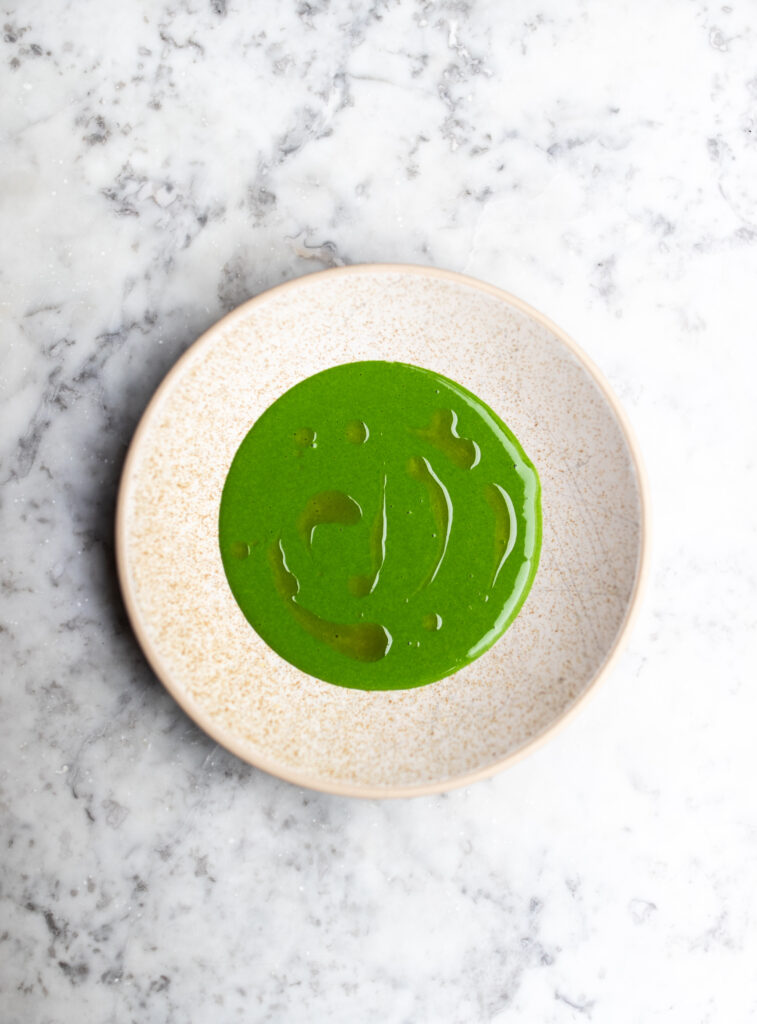 Chicken & pork parsley sauce in a white bowl on a marble tabletop